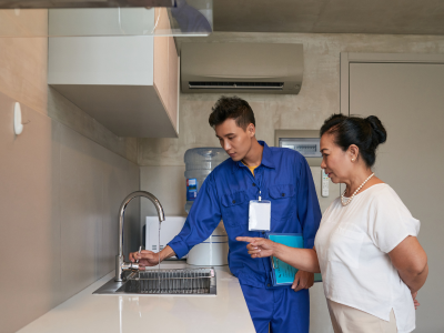 Close-up of a plumber applying plumber’s tape to a threaded faucet connection to ensure a watertight seal.
